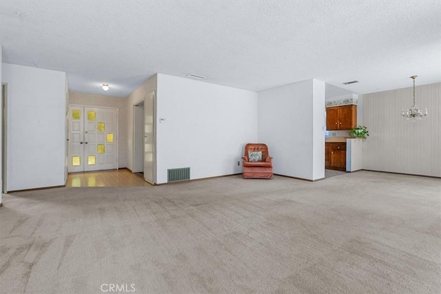 1283 W Newport St, San Luis Obispo, CA 93405 - unfurnished living room featuring a chandelier, light colored carpet, and a textured ceiling