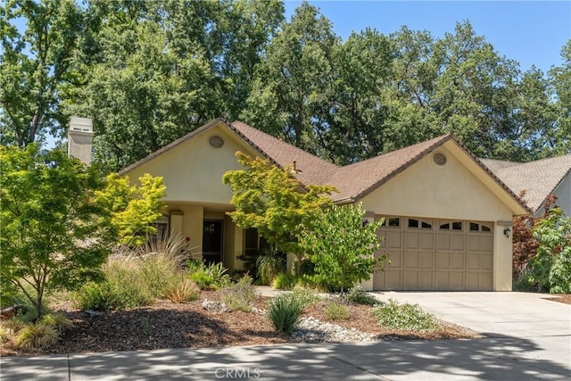 17 Arminta Ct, Chico, CA 95928 - obstructed view of property with a garage, concrete driveway, and stucco siding