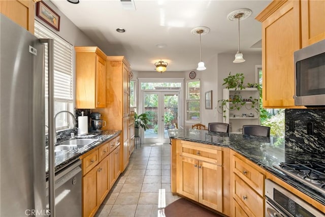 17 Arminta Ct, Chico, CA 95928 - kitchen with appliances with stainless steel finishes, hanging light fixtures, dark stone counters, light tile patterned flooring, and tasteful backsplash