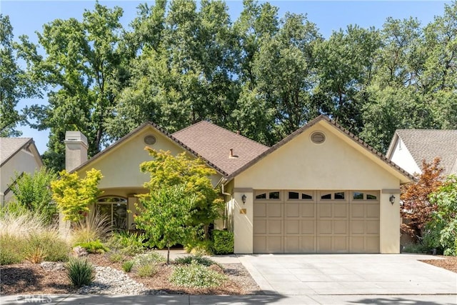 17 Arminta Ct, Chico, CA 95928 - view of front of house featuring an attached garage, driveway, stucco siding, and a chimney