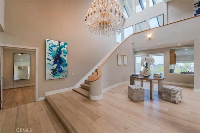 15541 Aqua Verde Dr, Los Angeles, CA 90077 - stairway with hardwood / wood-style flooring, a towering ceiling, a chandelier, and recessed lighting