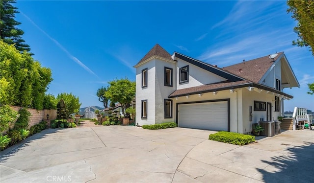 15541 Aqua Verde Dr, Los Angeles, CA 90077 - view of side of home with stucco siding, concrete driveway, and a shingled roof