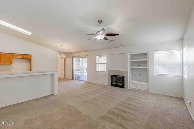 4810 Bluestone Dr, Bakersfield, CA 93311 - unfurnished living room with light colored carpet, a ceiling fan, built in shelves, a tile fireplace, and lofted ceiling