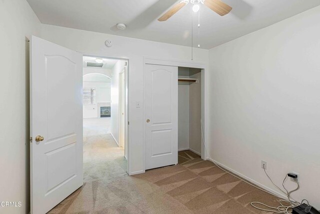4810 Bluestone Dr, Bakersfield, CA 93311 - unfurnished bedroom with light carpet, arched walkways, a closet, and a ceiling fan