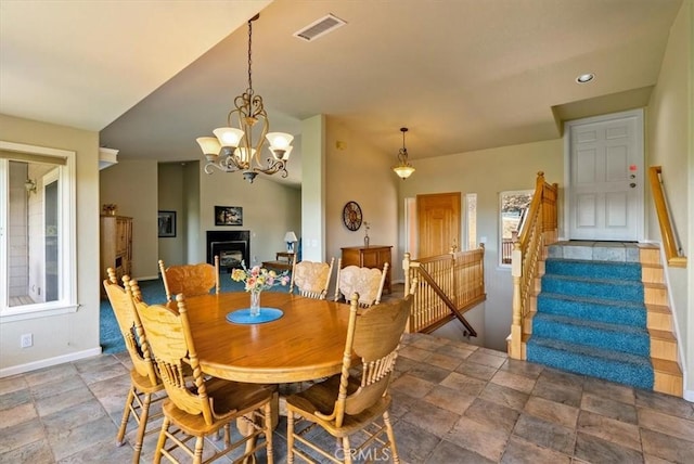 8412 Alta Vista Ave, Atascadero, CA 93422 - dining area with stone finish floors, a fireplace, stairs, a chandelier, and lofted ceiling