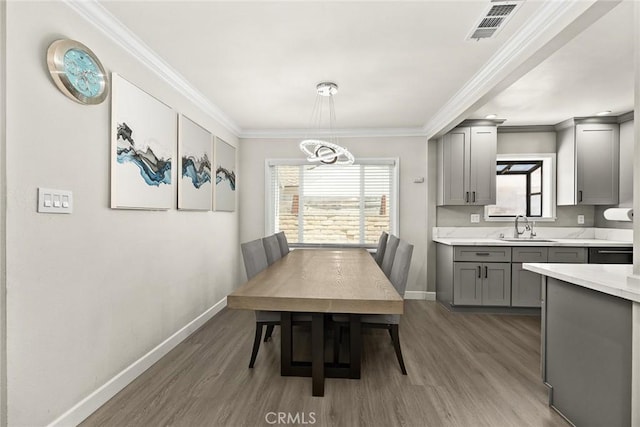 1834 E Stuart Ave, West Covina, CA 91791 - dining room featuring wood finished floors, healthy amount of natural light, ornamental molding, and a chandelier