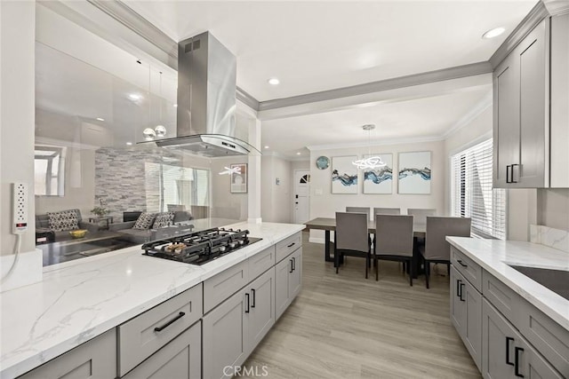 1834 E Stuart Ave, West Covina, CA 91791 - kitchen with island range hood, black gas stovetop, gray cabinetry, crown molding, and light stone counters