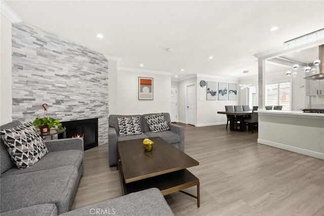 1834 E Stuart Ave, West Covina, CA 91791 - living area with ornamental molding, a fireplace, a chandelier, recessed lighting, and wood finished floors