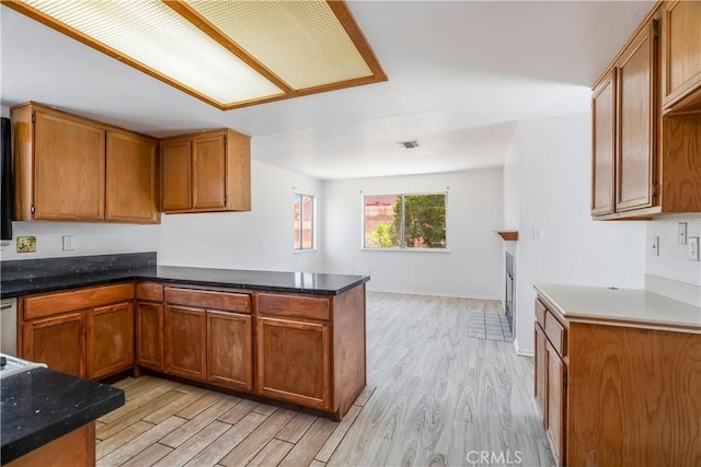 44738 Foxboro Ct, Lancaster, CA 93535 - kitchen featuring light wood-style floors, brown cabinetry, and a peninsula
