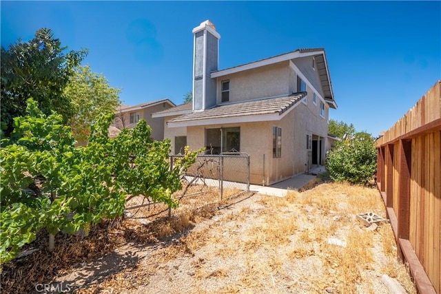 44738 Foxboro Ct, Lancaster, CA 93535 - back of property with stucco siding and a chimney