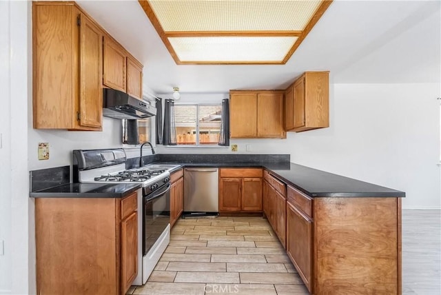 44738 Foxboro Ct, Lancaster, CA 93535 - kitchen with range with gas stovetop, under cabinet range hood, dishwasher, wood finish floors, and a peninsula