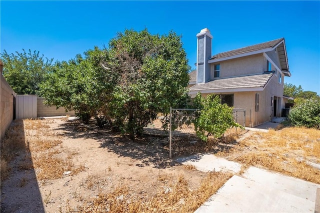 44738 Foxboro Ct, Lancaster, CA 93535 - rear view of house featuring a chimney and stucco siding