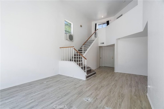 44738 Foxboro Ct, Lancaster, CA 93535 - unfurnished living room with wood finished floors, stairs, and a high ceiling