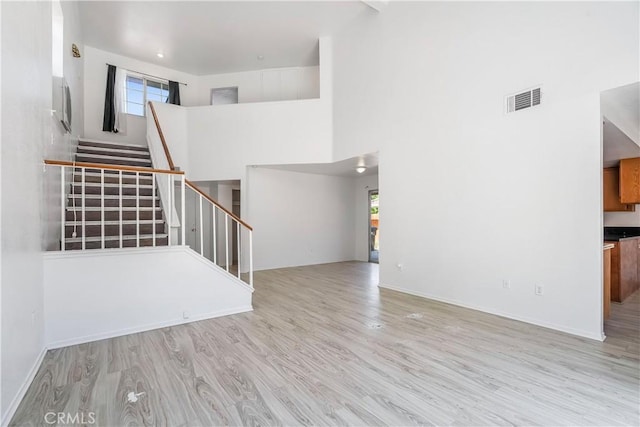 44738 Foxboro Ct, Lancaster, CA 93535 - unfurnished living room with wood finished floors, stairs, and a high ceiling