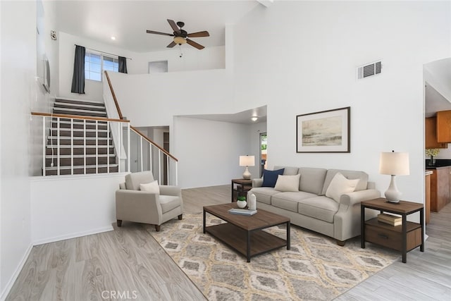 44738 Foxboro Ct, Lancaster, CA 93535 - living room with wood finished floors, a ceiling fan, stairs, and a towering ceiling