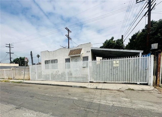 315 W 63rd Pl, Los Angeles, CA 90003 - view of front of property featuring a fenced front yard, stucco siding, a carport, and a gate