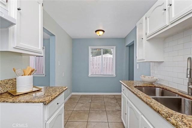 1048 S Record Ave, East Los Angeles, CA 90023 - kitchen with backsplash, white cabinetry, light stone countertops, and light tile patterned flooring