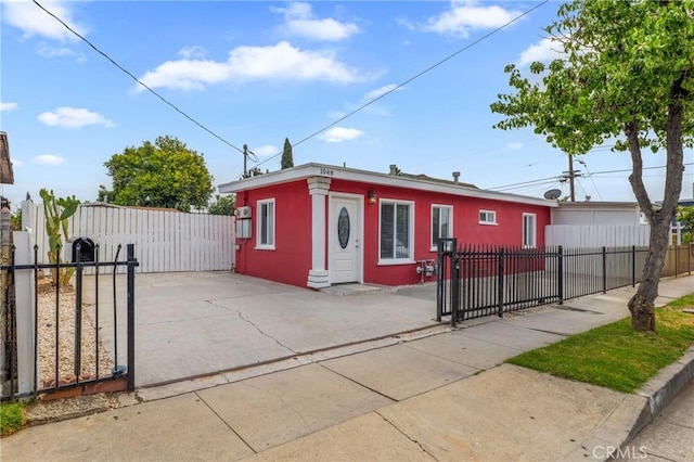 1048 S Record Ave, East Los Angeles, CA 90023 - view of front of home with a gate, a fenced front yard, and stucco siding