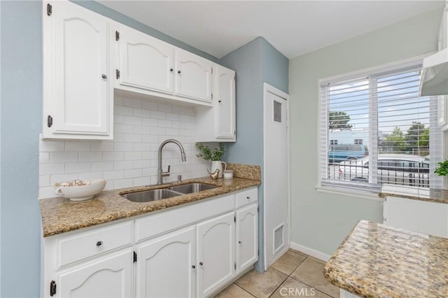 1048 S Record Ave, East Los Angeles, CA 90023 - kitchen with white cabinets, backsplash, light tile patterned floors, and light stone countertops