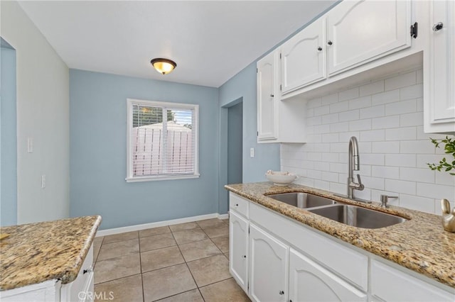 1048 S Record Ave, East Los Angeles, CA 90023 - kitchen featuring backsplash, white cabinetry, and light stone counters