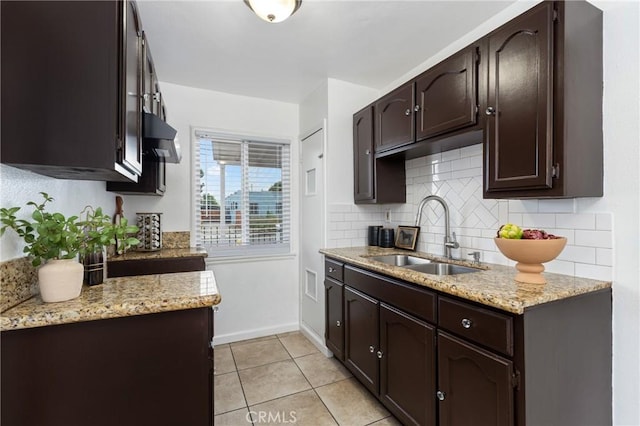 1048 S Record Ave, East Los Angeles, CA 90023 - kitchen with dark brown cabinetry, backsplash, and light stone counters