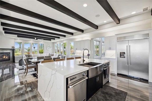 36472 County Line Rd, Yucaipa, CA 92399 - kitchen with stainless steel built in fridge, beam ceiling, plenty of natural light, an island with sink, and open floor plan
