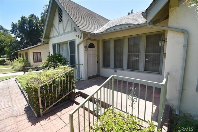 565 N Laurel Ave, Upland, CA 91786 - doorway to property featuring stucco siding, a shingled roof, and covered porch