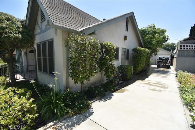 565 N Laurel Ave, Upland, CA 91786 - view of side of home featuring stucco siding, a detached garage, and an outbuilding