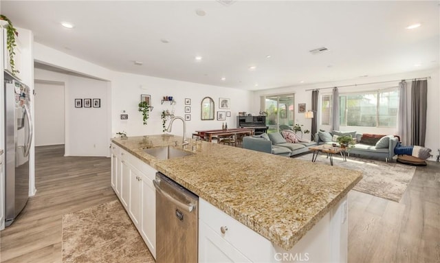 10963 Clementine Way, Loma Linda, CA 92354 - kitchen with stainless steel appliances, a kitchen island with sink, white cabinets, light wood-type flooring, and open floor plan