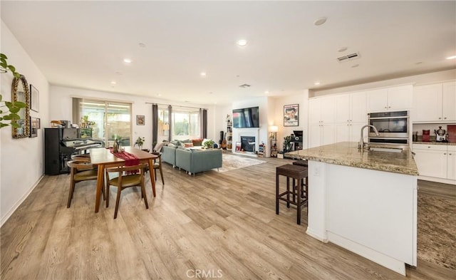 10963 Clementine Way, Loma Linda, CA 92354 - dining room with light wood-type flooring, recessed lighting, and a glass covered fireplace