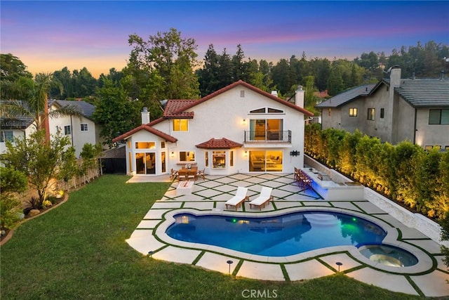 11900 Laughton Way, Porter Ranch, CA 91326 - back of property at dusk with a balcony, a chimney, a patio area, and stucco siding