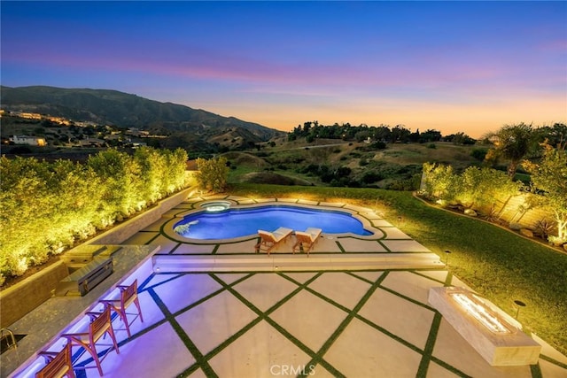 11900 Laughton Way, Porter Ranch, CA 91326 - pool at dusk featuring a mountain view, a patio area, and a pool with connected hot tub