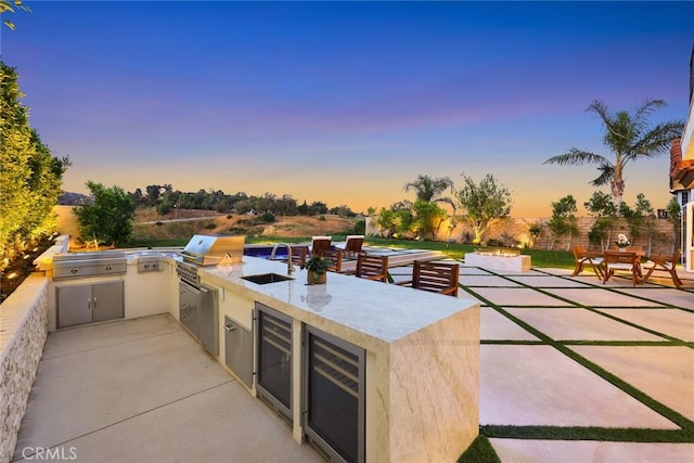 11900 Laughton Way, Porter Ranch, CA 91326 - patio terrace at dusk with wine cooler, a patio area, and area for grilling
