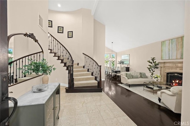 11900 Laughton Way, Porter Ranch, CA 91326 - foyer entrance with stairs, high vaulted ceiling, and a warm lit fireplace