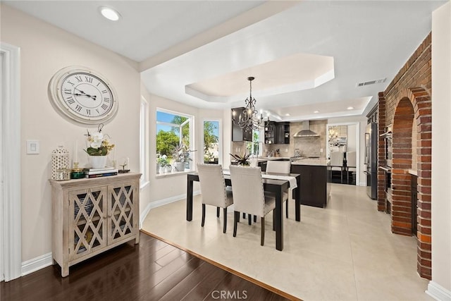 11900 Laughton Way, Porter Ranch, CA 91326 - dining space featuring a chandelier, recessed lighting, a brick fireplace, and a raised ceiling