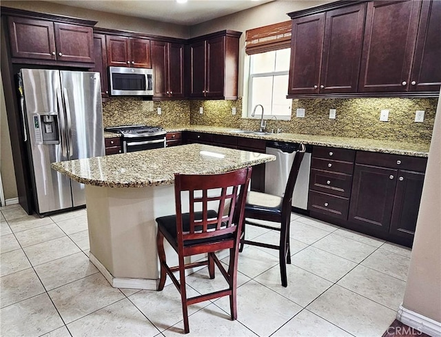 15048 Westin Ln, La Mirada, CA 90638 - kitchen with appliances with stainless steel finishes, tasteful backsplash, light stone counters, and a center island
