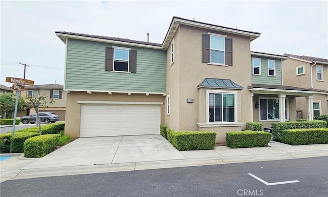 15048 Westin Ln, La Mirada, CA 90638 - view of front of house featuring stucco siding, an attached garage, concrete driveway, and a standing seam roof