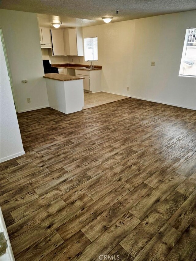 13325 Kornblum Ave, Hawthorne, CA 90250 - kitchen featuring dark wood-style flooring, a peninsula, open floor plan, and a textured ceiling