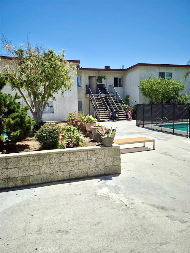 13325 Kornblum Ave, Hawthorne, CA 90250 - view of front of house with stairway, stucco siding, and a patio area