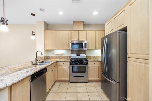8015 Yeager St, Chino, CA 91708 - kitchen with light brown cabinets, appliances with stainless steel finishes, light tile patterned floors, light stone counters, and a peninsula