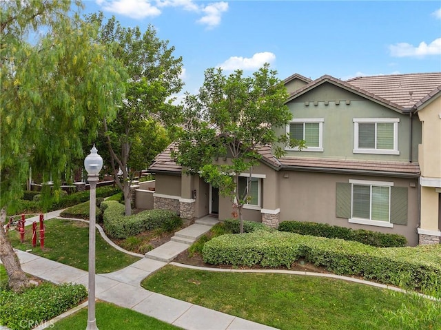 8015 Yeager St, Chino, CA 91708 - view of front of home with stone siding, stucco siding, a tile roof, and a front yard