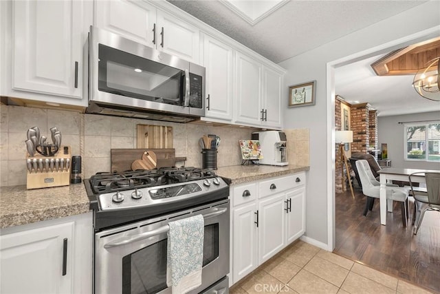 3112 N Hearthside St, Orange, CA 92865 - kitchen with appliances with stainless steel finishes, light tile patterned floors, white cabinetry, and light countertops