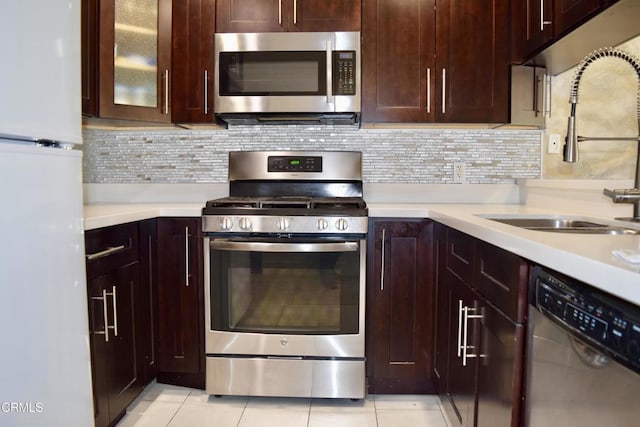 10149 Commerce Ave Unit 2, Tujunga, CA 91042 - kitchen featuring appliances with stainless steel finishes, light tile patterned floors, light countertops, and backsplash