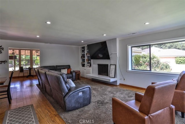 1853 E Renshaw St, Covina, CA 91724 - living area featuring hardwood / wood-style floors, crown molding, recessed lighting, a fireplace, and built in shelves