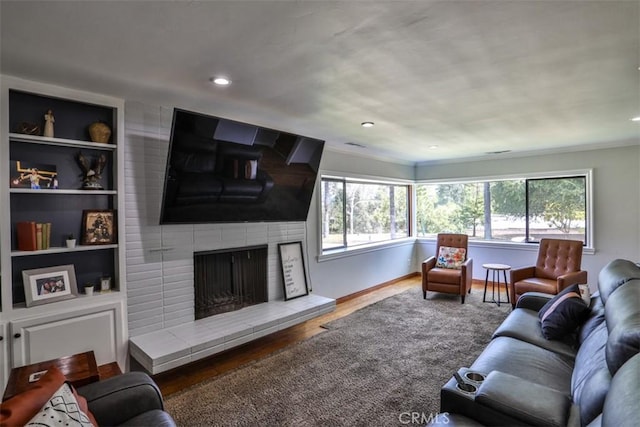 1853 E Renshaw St, Covina, CA 91724 - living room featuring wood finished floors, a tile fireplace, built in features, and recessed lighting