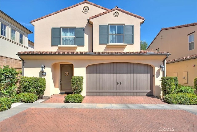 25 Sedgewick, Irvine, CA 92620 - mediterranean / spanish-style house with an attached garage, a tiled roof, stucco siding, and decorative driveway