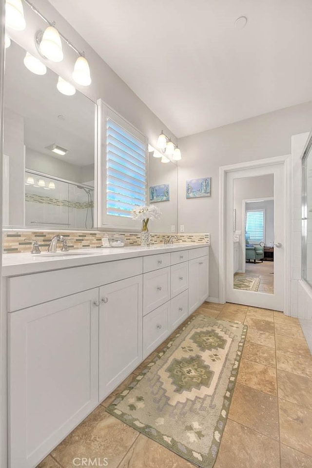 25 Sedgewick, Irvine, CA 92620 - bathroom featuring a shower with shower door, double vanity, and decorative backsplash