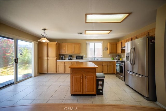 3309 Kaylyn St, Lancaster, CA 93535 - kitchen featuring stainless steel appliances, light countertops, a center island, light tile patterned floors, and pendant lighting