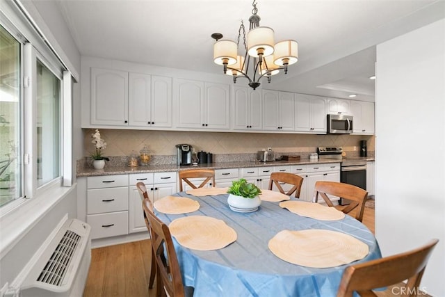 856 Ronda Mendoza Unit P, Laguna Woods, CA 92637 - dining area featuring light wood finished floors, a chandelier, and a wall mounted air conditioner