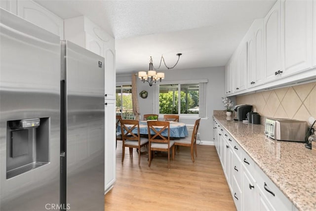856 Ronda Mendoza Unit P, Laguna Woods, CA 92637 - kitchen featuring stainless steel refrigerator with ice dispenser, white cabinetry, light wood finished floors, and a chandelier